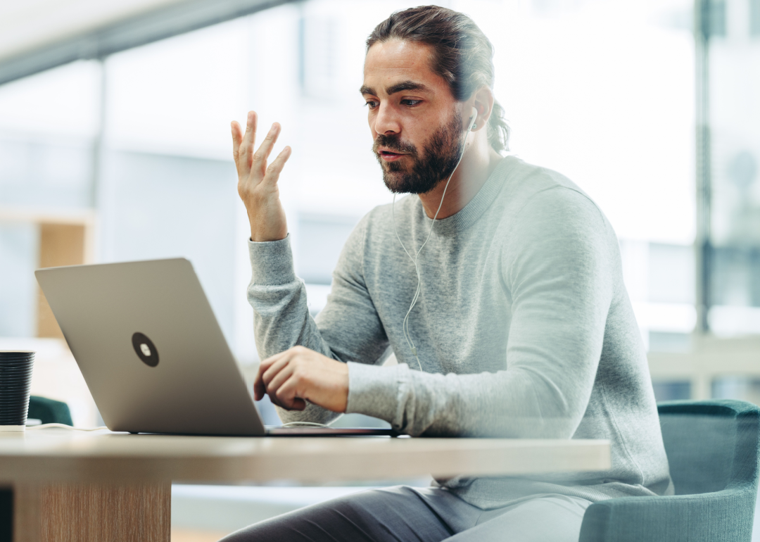 Businessman talking to associates during online meeting.