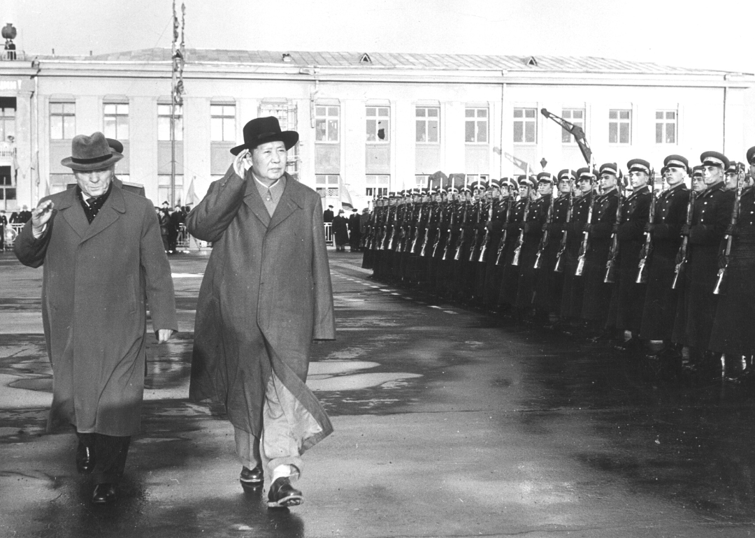 Mao Zedong and Kliment Yefremovich Voroshilov salute while reviewing an Honor Guard upon arrival at Moscow airport
