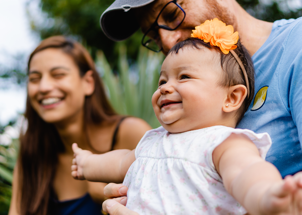 Girl with her parents smiling.