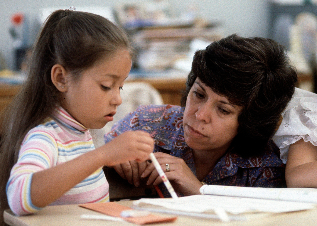 Teacher helping student with lesson in an elementary classroom.