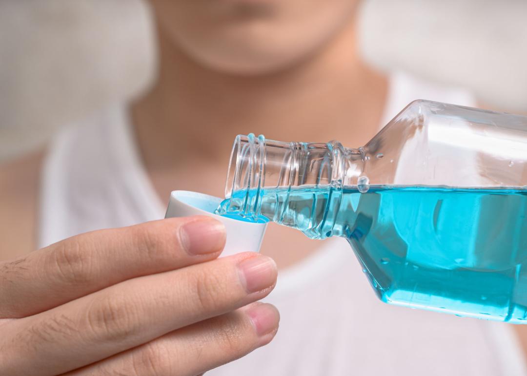 Hand of person pouring mouthwash into cap