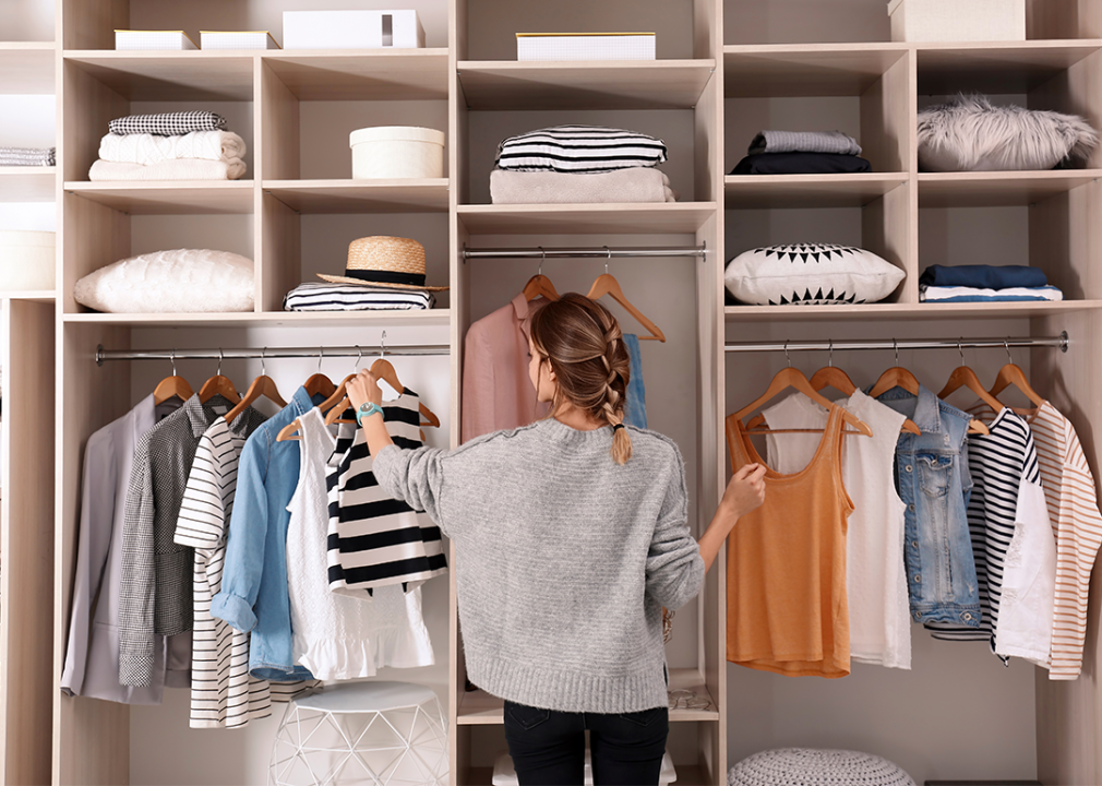 Woman choosing clothes from an edited wardrobe.