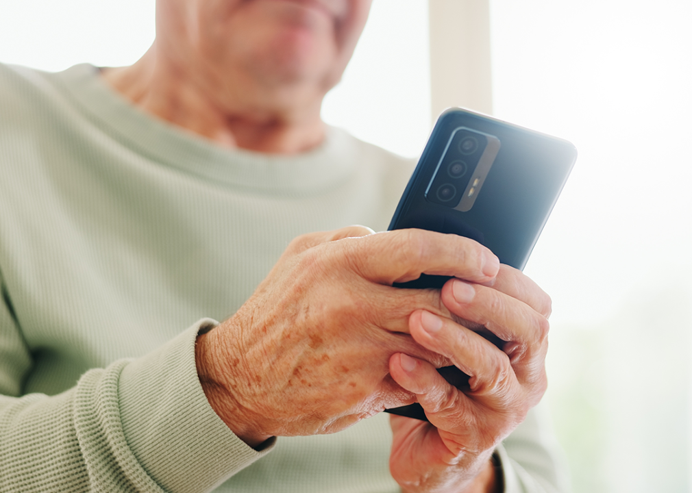 Close-up of an older person's hands holding phone.
