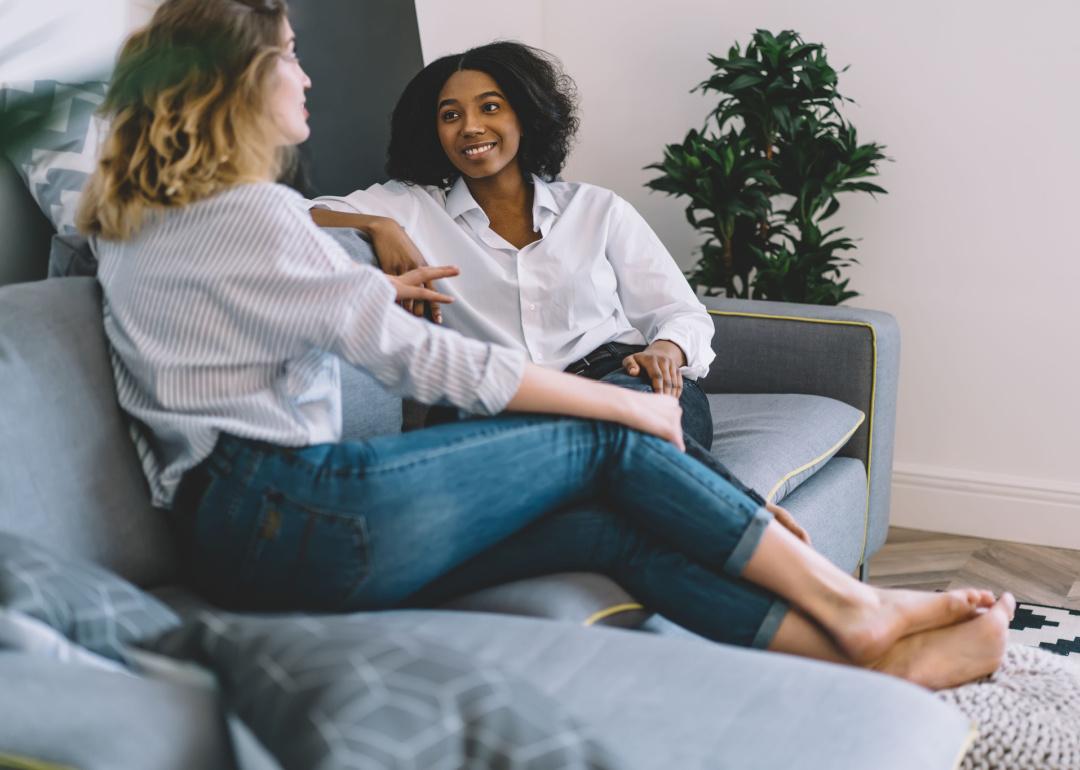 Two friends sitting on the living room couch.