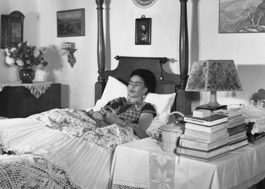Frida Kahlo lies in bed at her home.