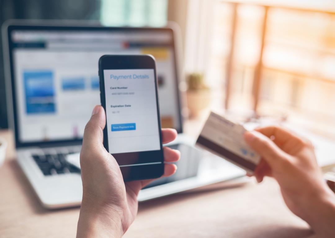 Hands using smartphone and laptop for online banking