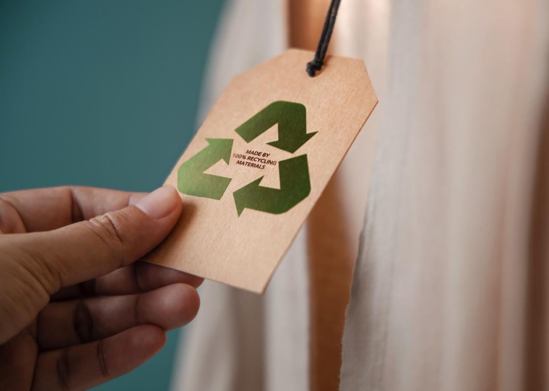 Close view hand holding recycled material tag on apparel