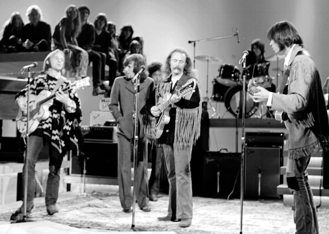 Crosby Stills Nash & Young performing on stage.