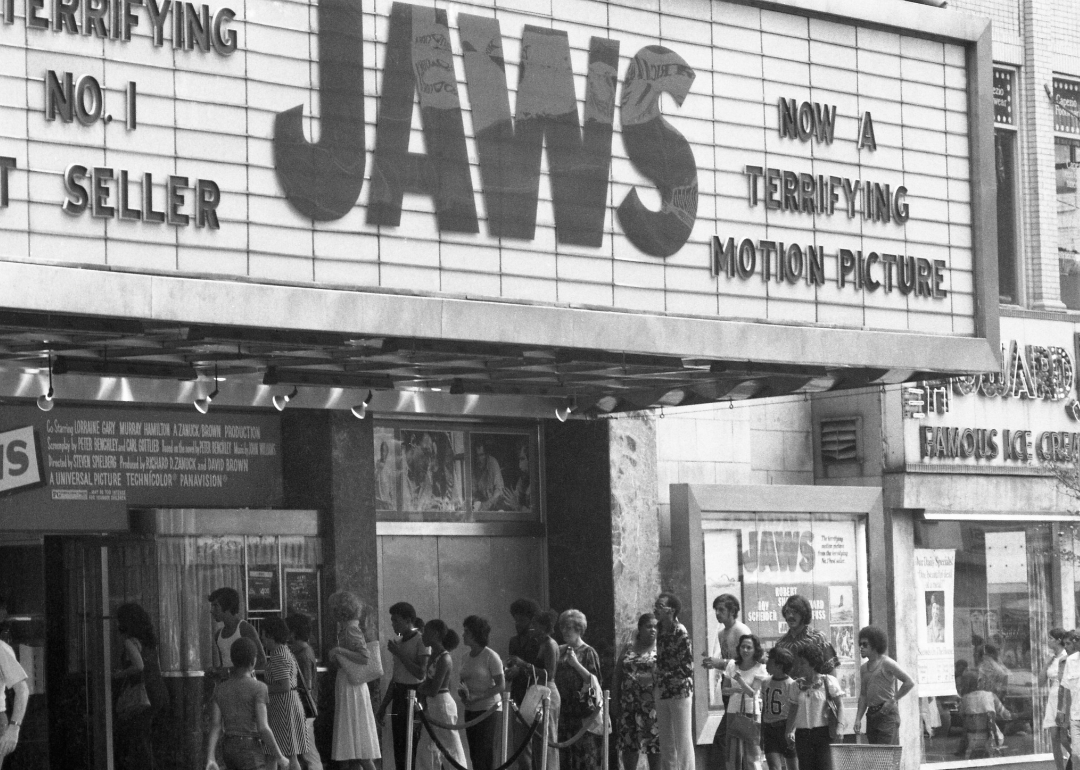 Crowds in line under movie marquee featuring ‘Jaws.'
