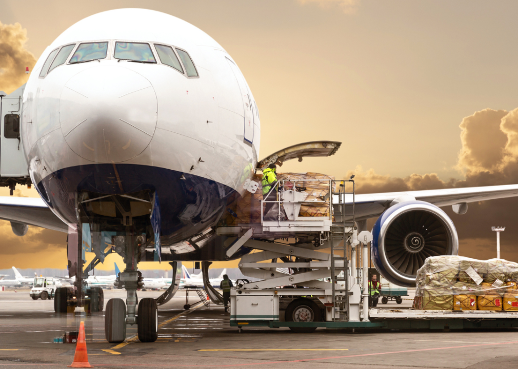 People loading cargo on plane