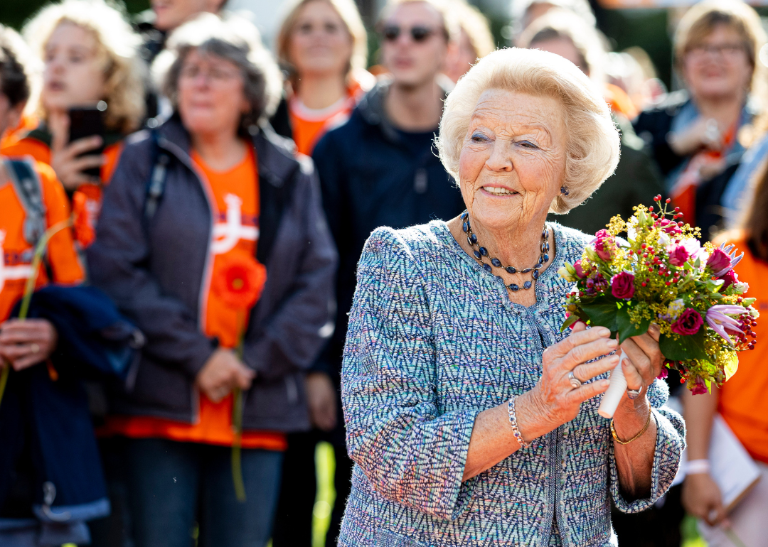 Princess Beatrix holding flowers at fundraiser.