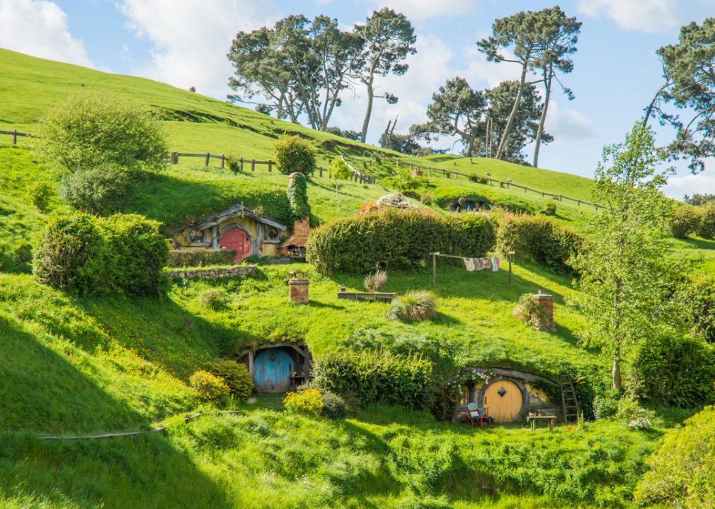 Exterior of three hobbit houses with a yellow, blue. and red doors