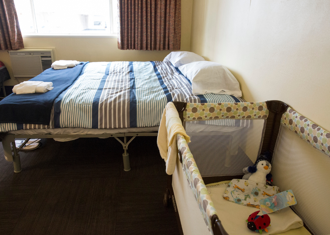 Inside a room with bed and crib at a former motel being used to house homeless