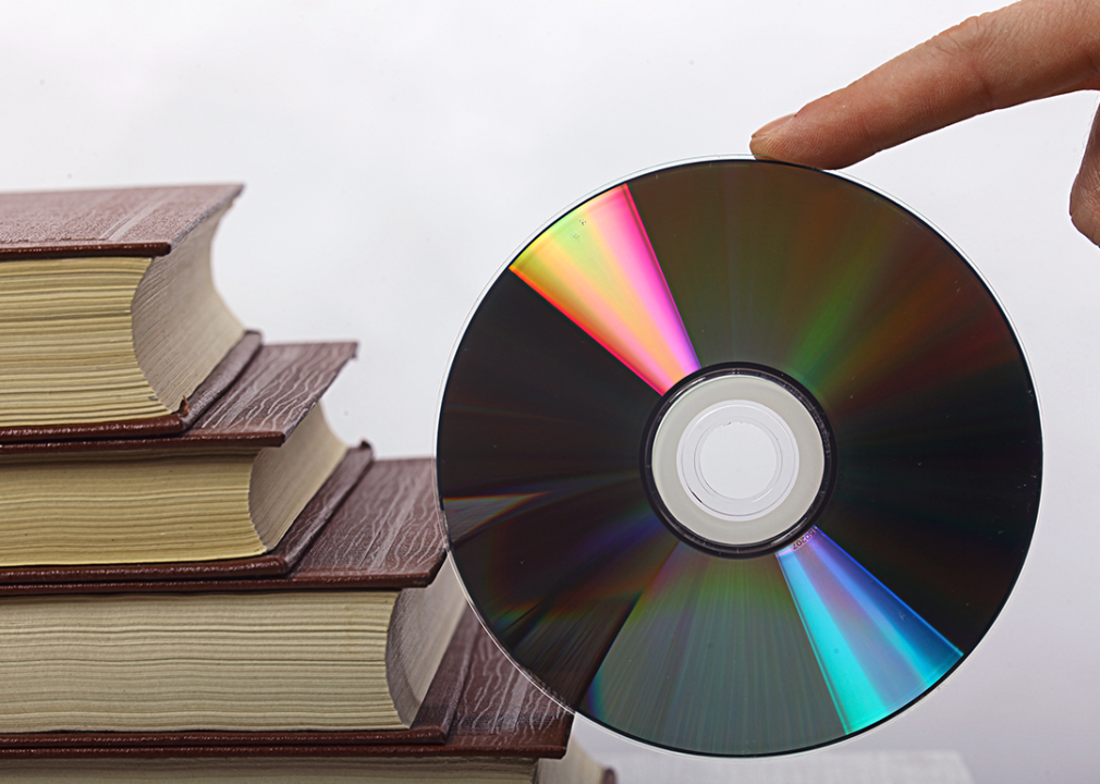 A stack of books next to a CD-ROM.