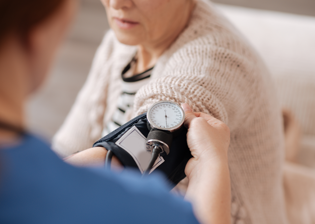 Home health aid checks a patient's blood pressure.