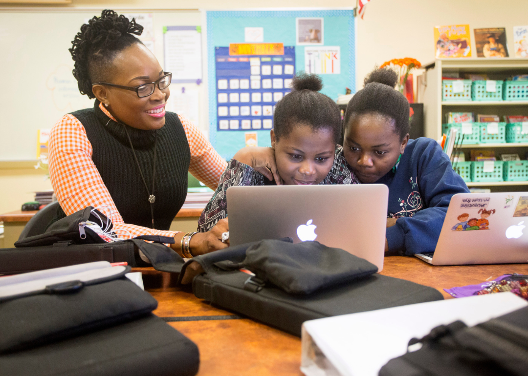 Teacher assisting two Tanzanian students in an English Language Learners class.