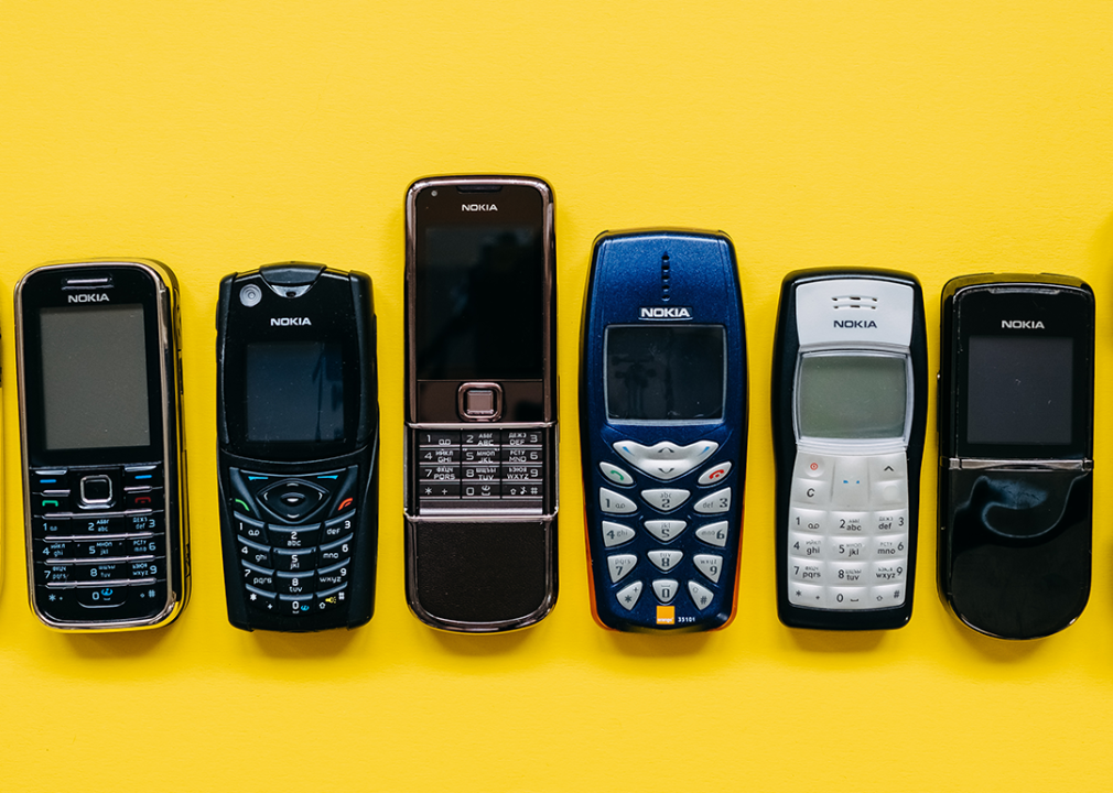 Collection of Nokia mobile phones on yellow background.