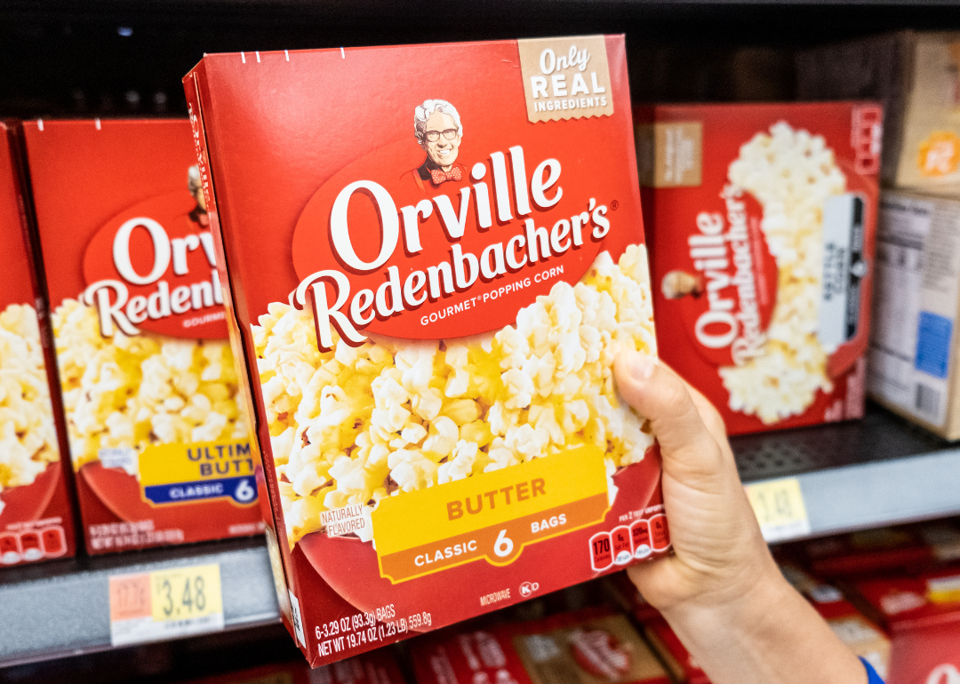 Hand holding box of Orville Redenbacher's popcorn.