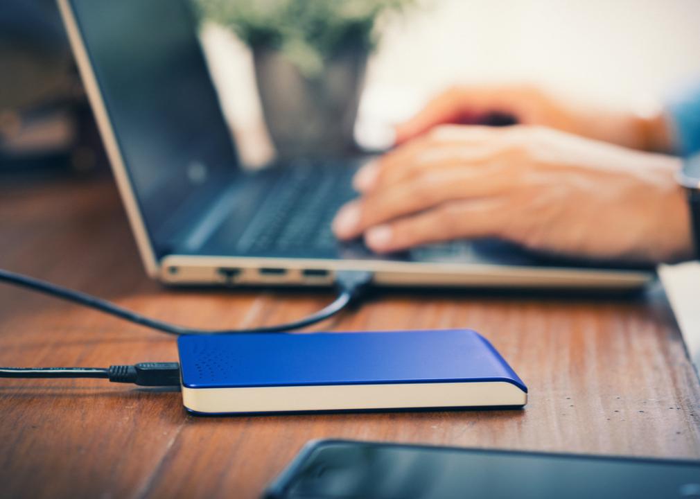 Photo shows a closeup of a person's hands typing on a laptop