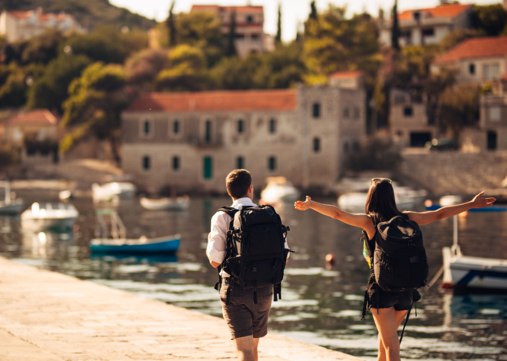 Backpacking couple walking along harbor