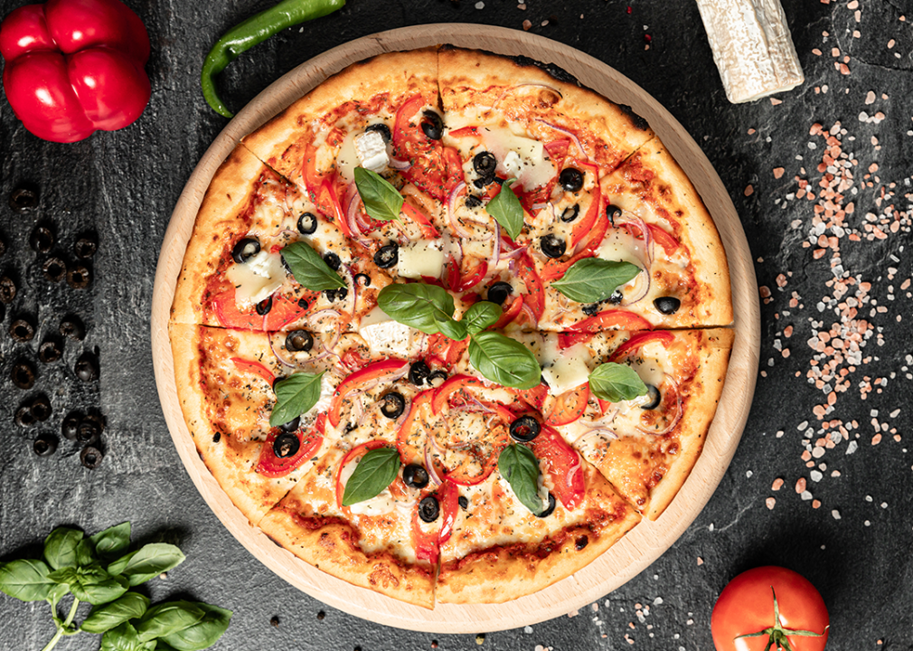 Top view pizza with vegetables and meat on table.