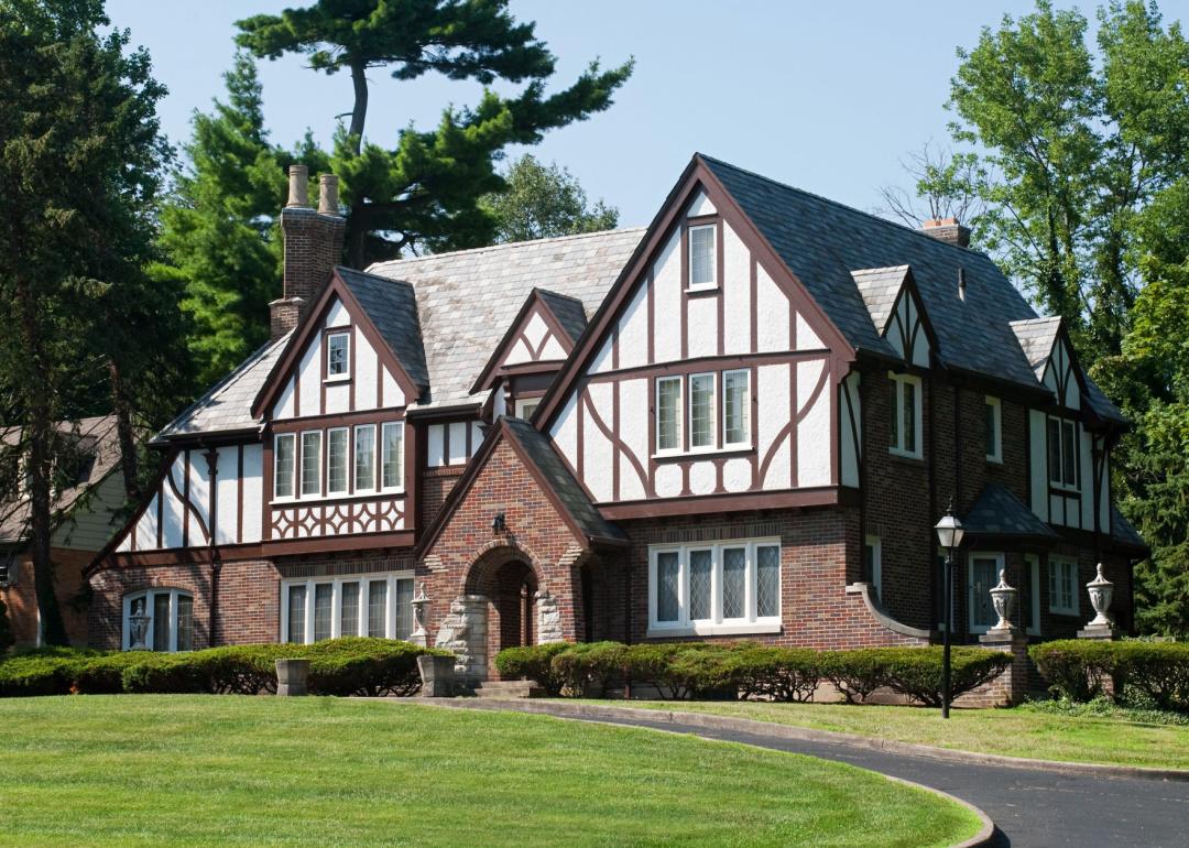 A Tudor-style home sits behind a curving driveway.