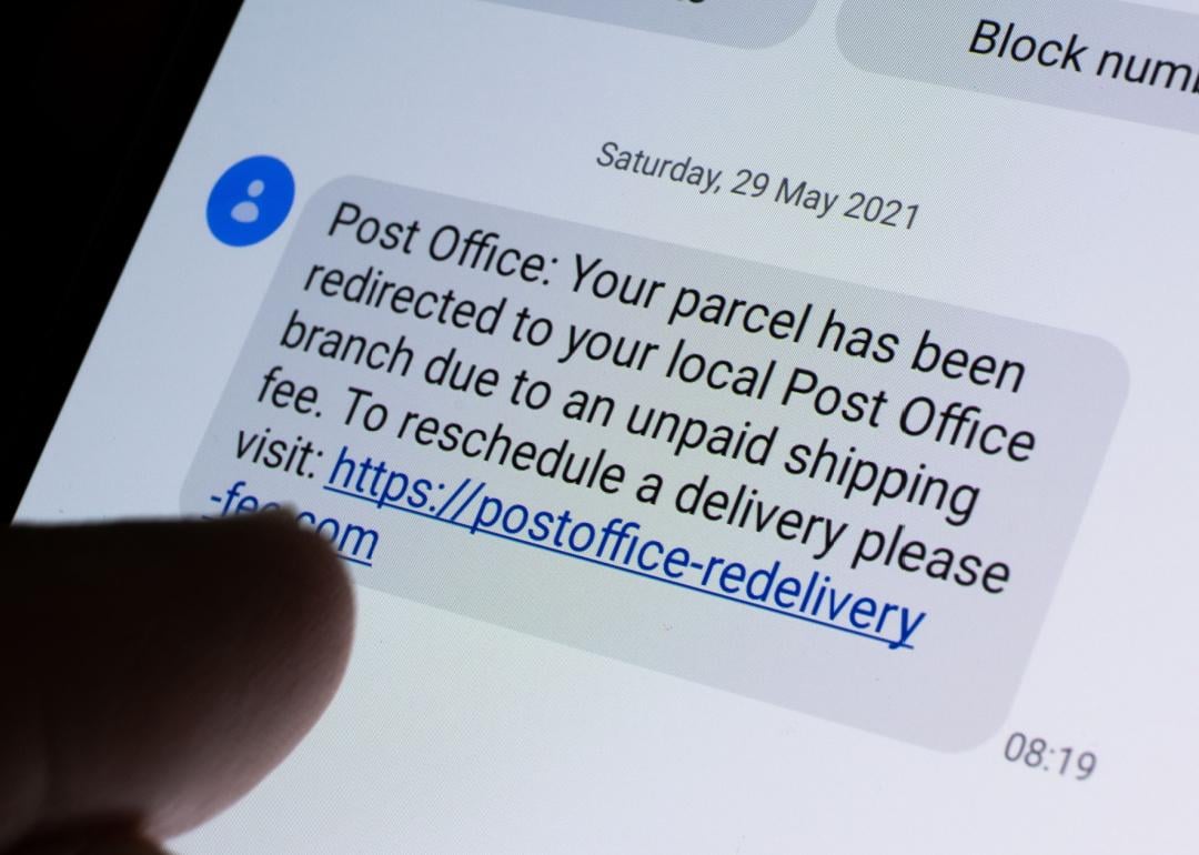 Post office scam text on phone screen.