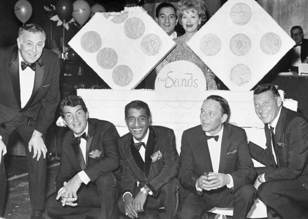 Dean Martin, Sammy Davis Jr., Danny Thomas, Lucille Ball, Frank Sinatra stand around a cake for the 11th anniversary of the Sands Hotel in Las Vegas.