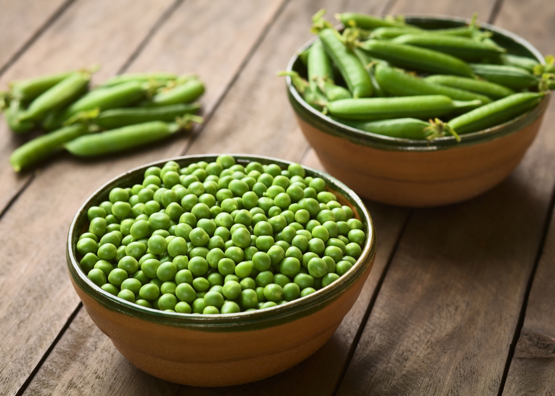 Shelled and unshelled peas in bowls.
