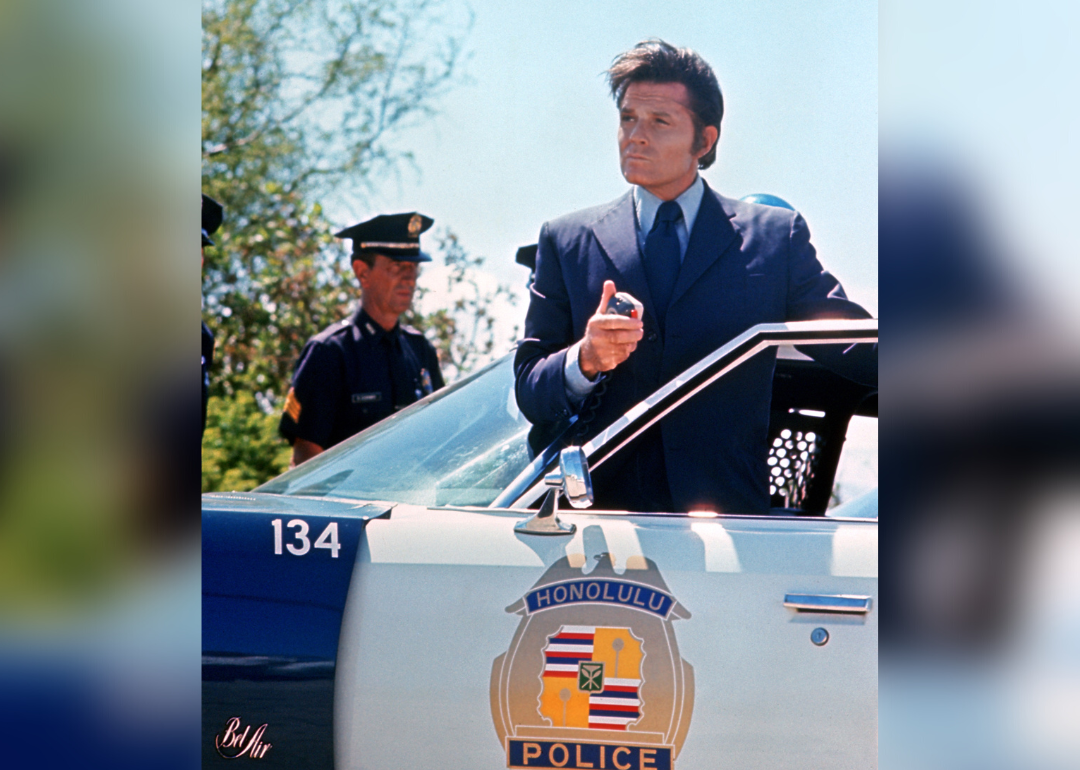 Jack Lord standing by police car in a publicity image for “Hawaii Five-0’.
