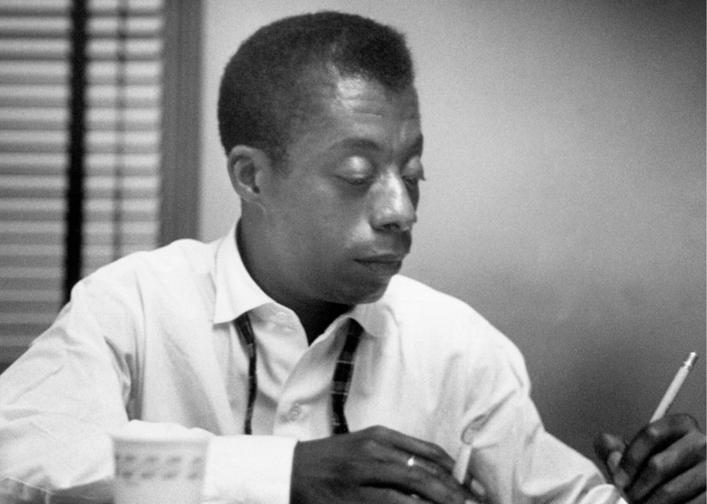 Portrait of James Baldwin writing at desk.