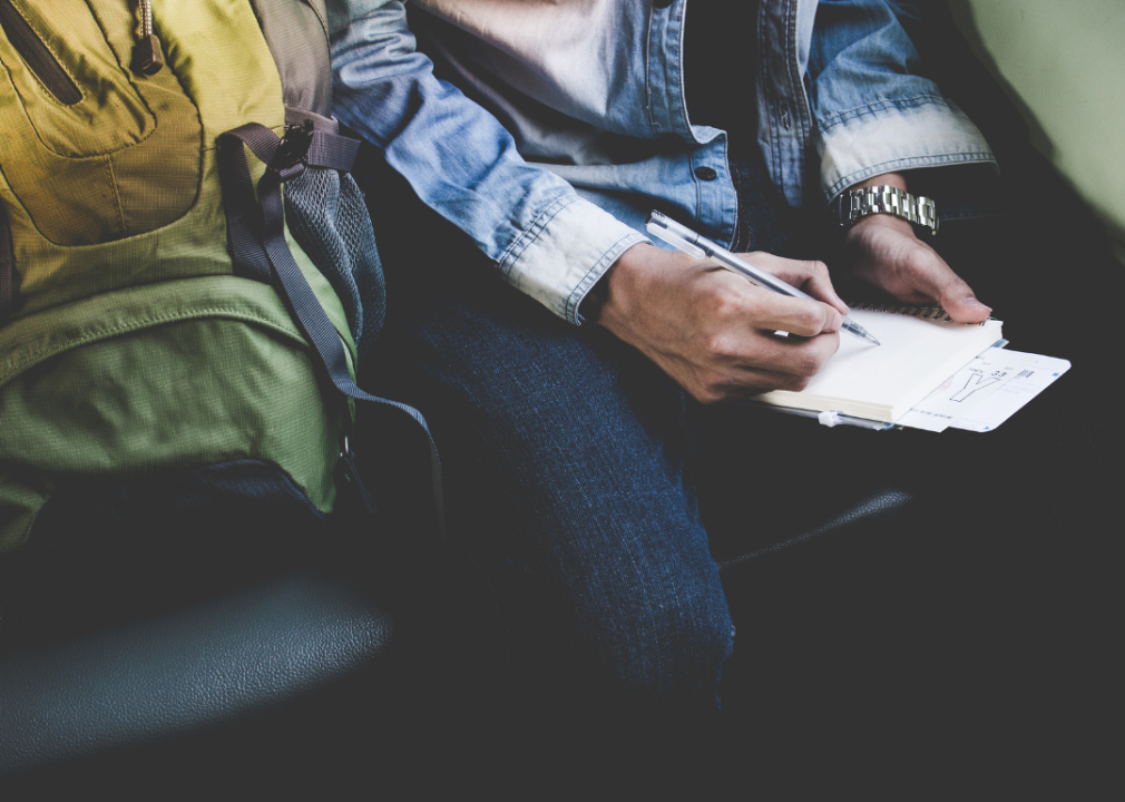 Man writing in journal on train