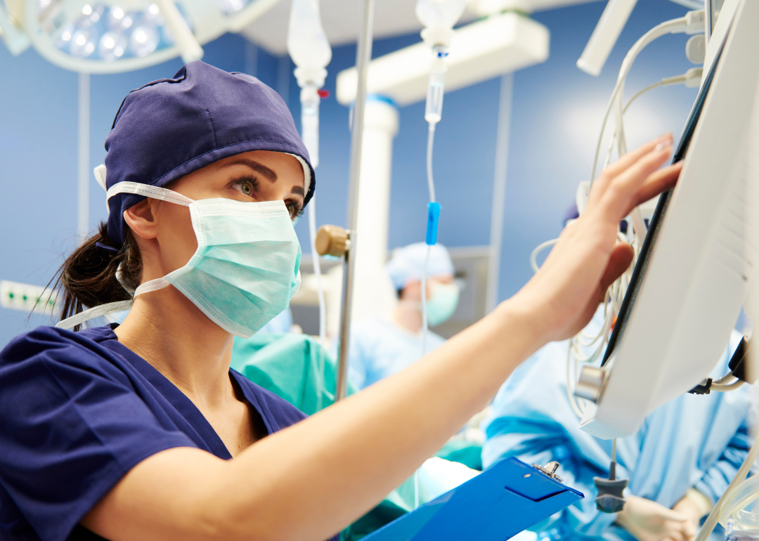 Nurse checking monitor in emergency room.