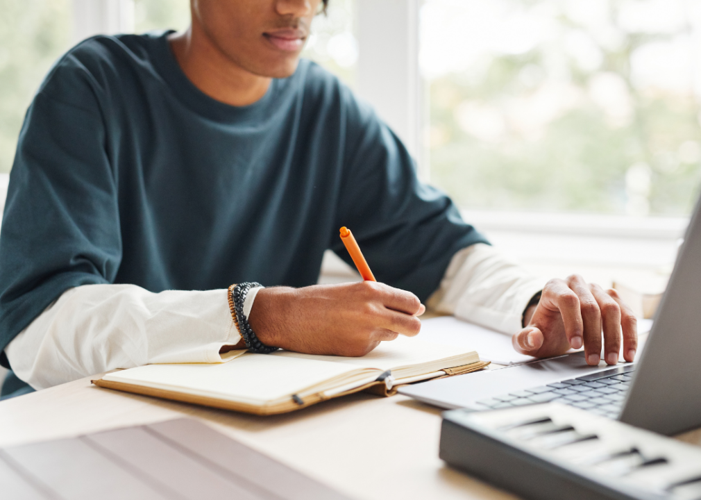 Teenage boy using laptop while studying