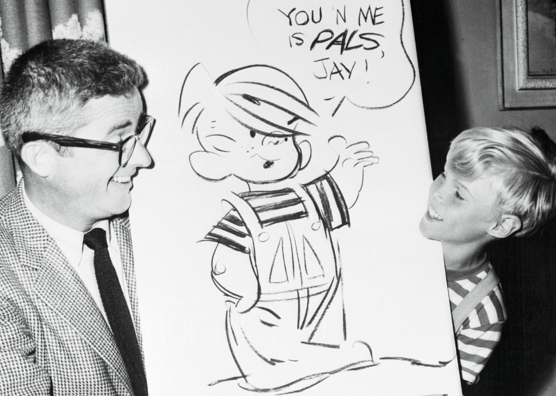 Jay North and Hank Ketcham looking at cartoon illustration of ‘Dennis The Menace’.