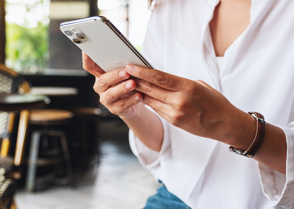 A woman holding and using Iphone 11 Pro Max smart phone.