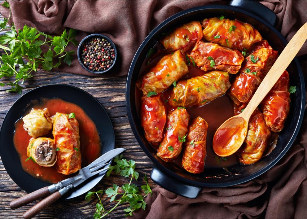 Stuffed cabbage in a large pot and on a small plate next to it. 