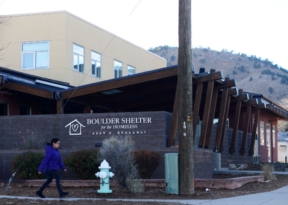 A woman walks past the front of the Boulder Shelter for the Homeless building.