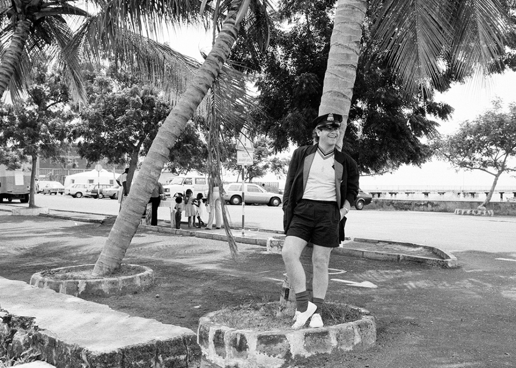 Elton John standing under a palm tree on Montserrat.