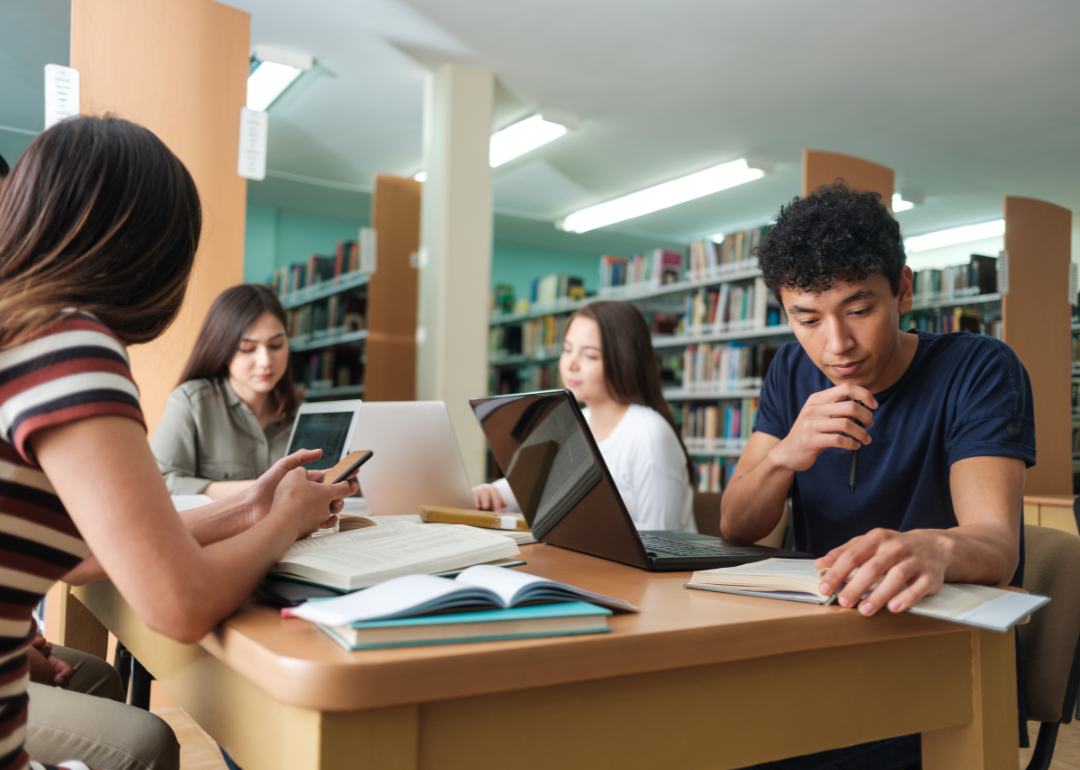 Group of students studying together in library.