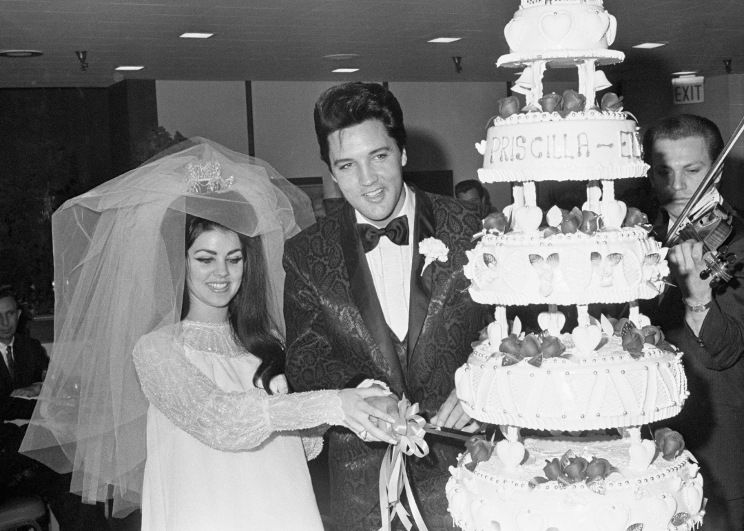 Elvis Presley and Priscilla Ann Beaulieu, 21, cut the cake at the Las Vegas reception following their wedding,