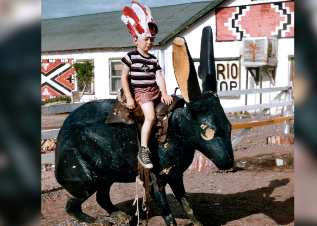 Boy sitting on giant cement rabbit at trading post.