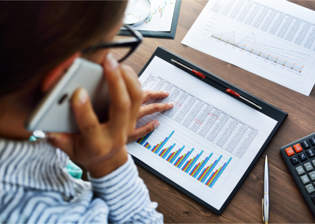 Analyst reviews spreadsheet and financial data.
