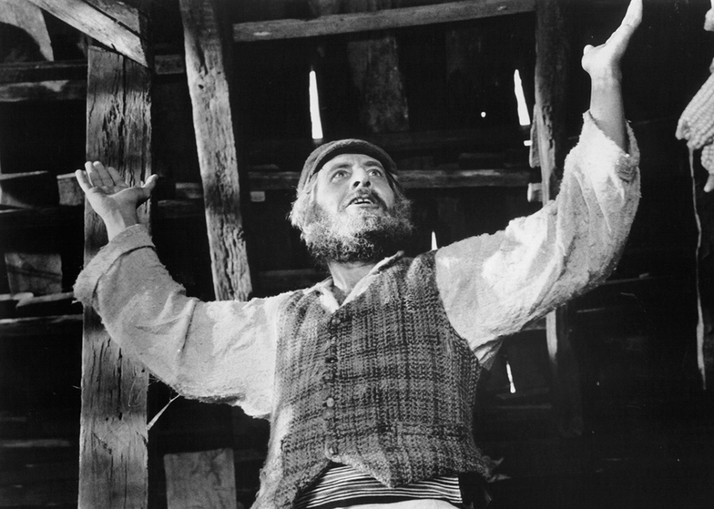Topol raising hands in the air in a scene from ‘Fiddler on the Roof’.