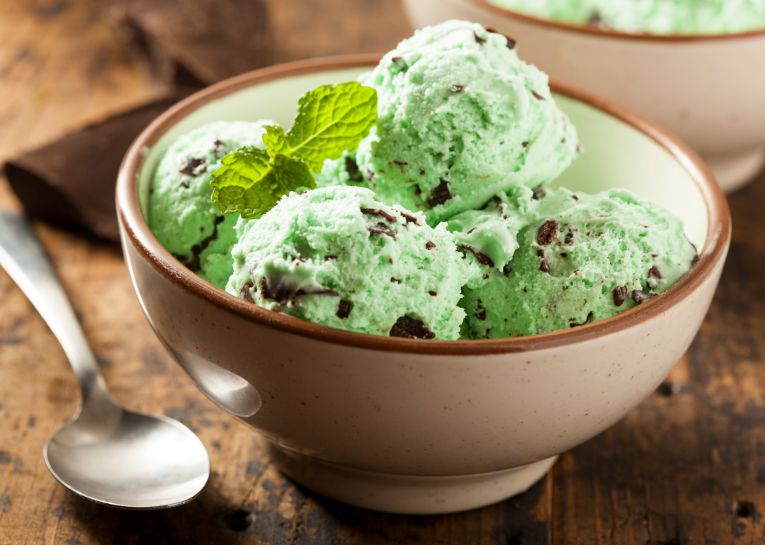 Green chocolate mint chip ice cream in bowl with spoon.