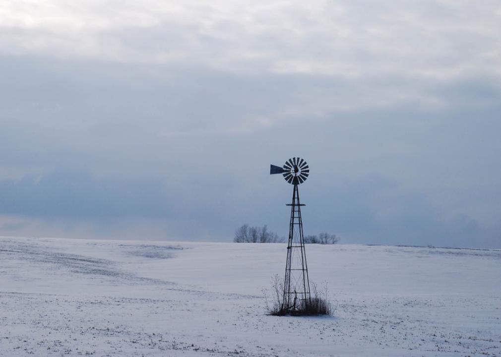A windmill in a snowy winter landscape.