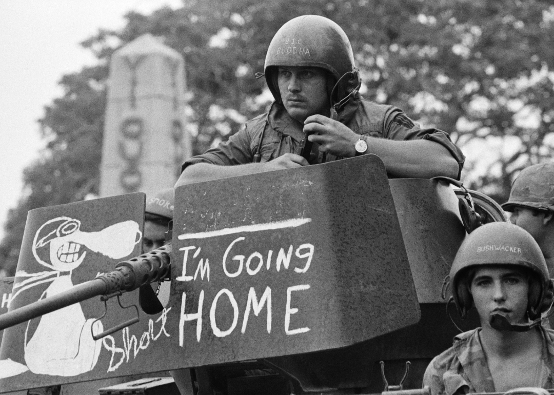 GI looking out over tank gun mount painted with “I’m going home."