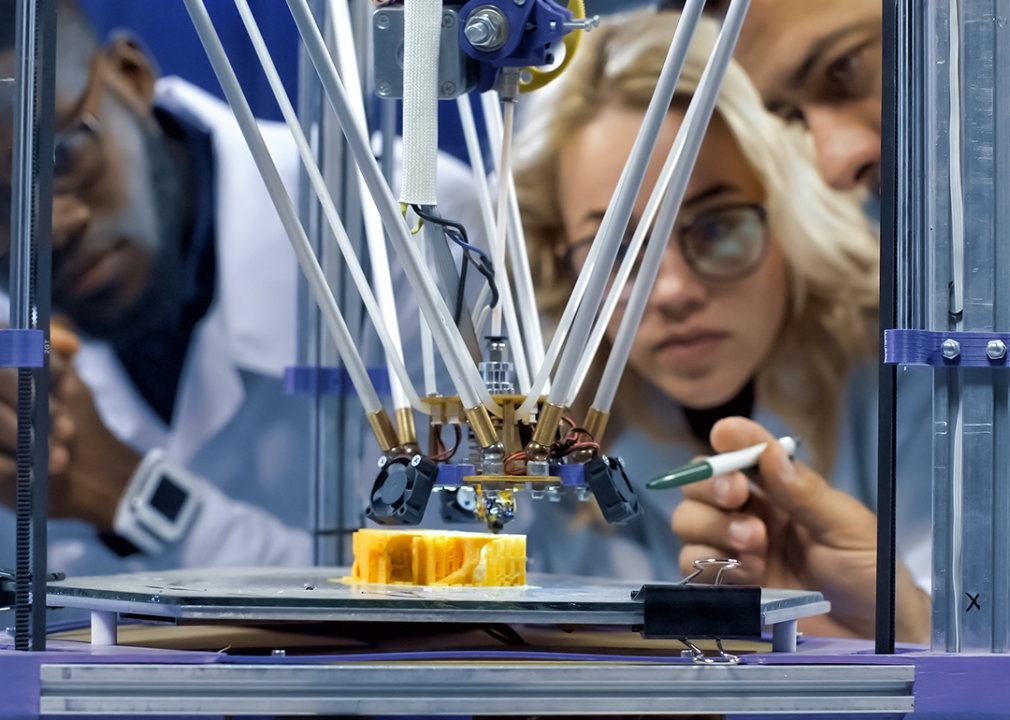 Scientists watching model production in 3D printer.