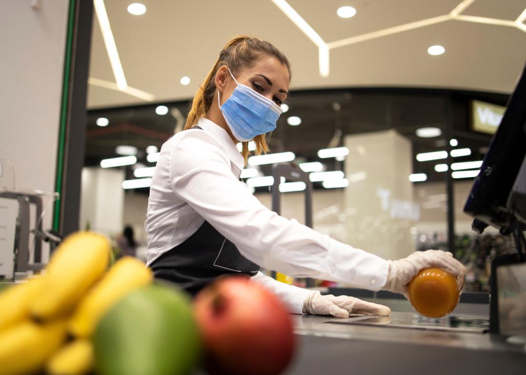 Supermarket cashier scanning items at checkout.