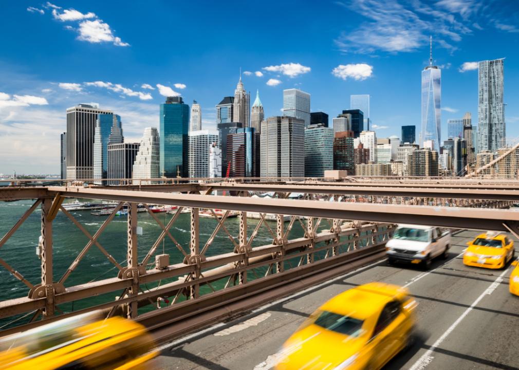 Cabs crossing the Brooklyn Bridge with Manhattan skyline.